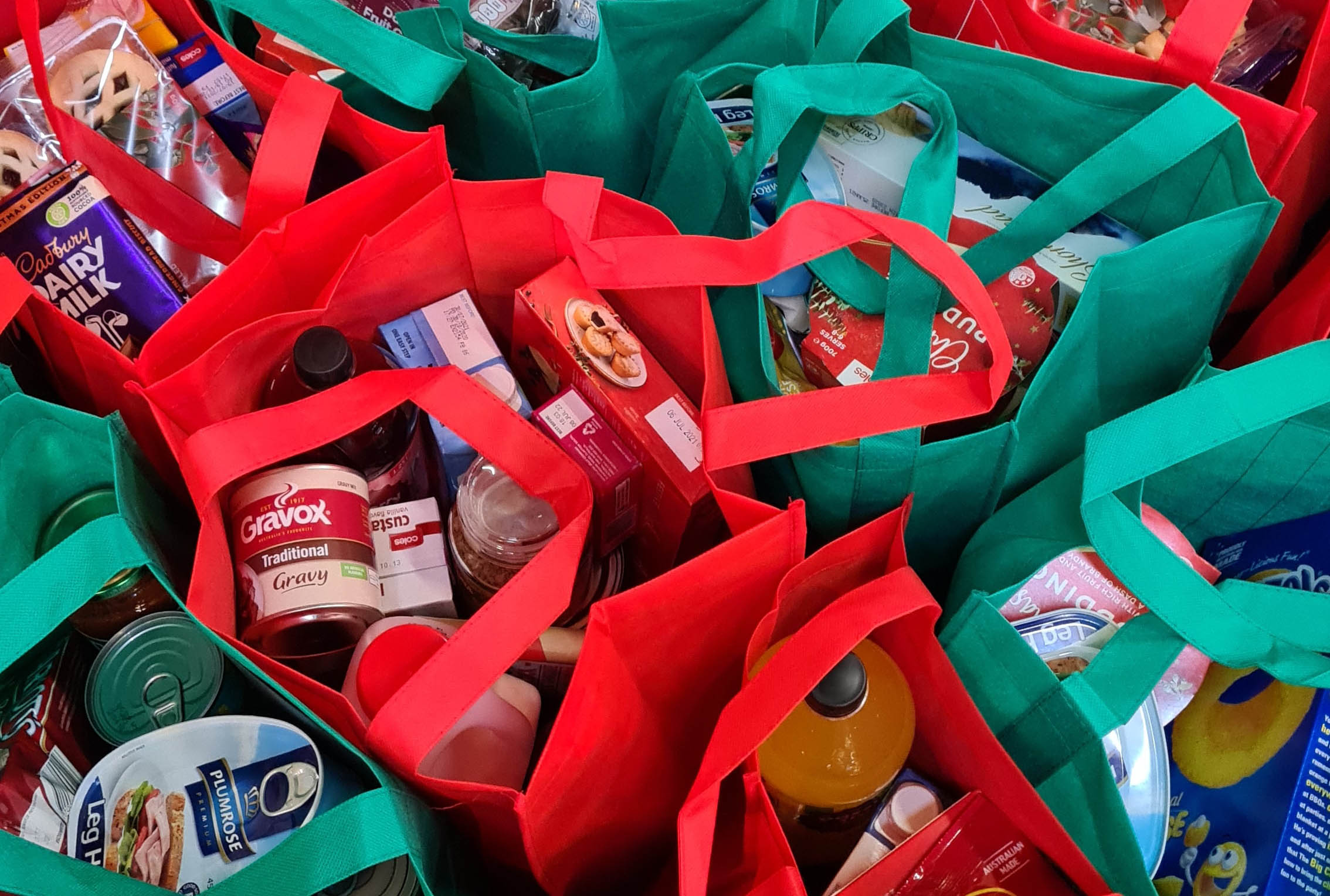 Red & Green bags full of canned goods and boxed items